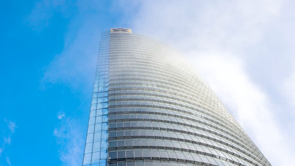 Nebelschwaden ziehen an der DHL-Zentrale am Posttower vorbei. Oben ist das Logo für das Briefgeschäft zu sehen, das Posthorn. Foto: Thomas Banneyer/dpa