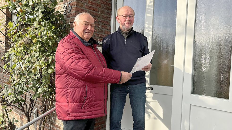 Ortsbürgermeister Bernhard Robbers (links) verteilte in Langholt Zettel an die Einwohner. Er kündigt in dem Schreiben seinen Rücktritt an. Hier nimmt Heinrich Schütte das Schreiben in Empfang. Foto: Kruse