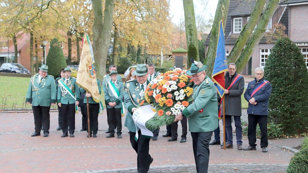 Fahnenabordnungen nahmen Aufstellungen vor dem Denkmal für die Toten beider Weltkriege in Harkebrügge. Foto: Passmann