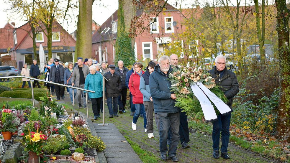 Nach dem Gottesdienst in der Suurhuser Kirche führte die stille Prozession über den Friedhof zum Kriegsmahnmal, wo der Kranz niedergelegt wurde. Foto: Wagenaar