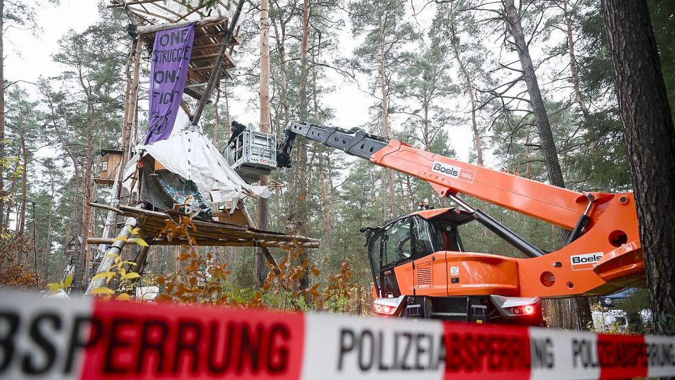 Mit Hilfe einer Hebebühne kommen die Polizeikräfte an die Baumhäuser im aufgelösten Tesla-Protestcamp heran. Foto: Sebastian Christoph Gollnow/dpa