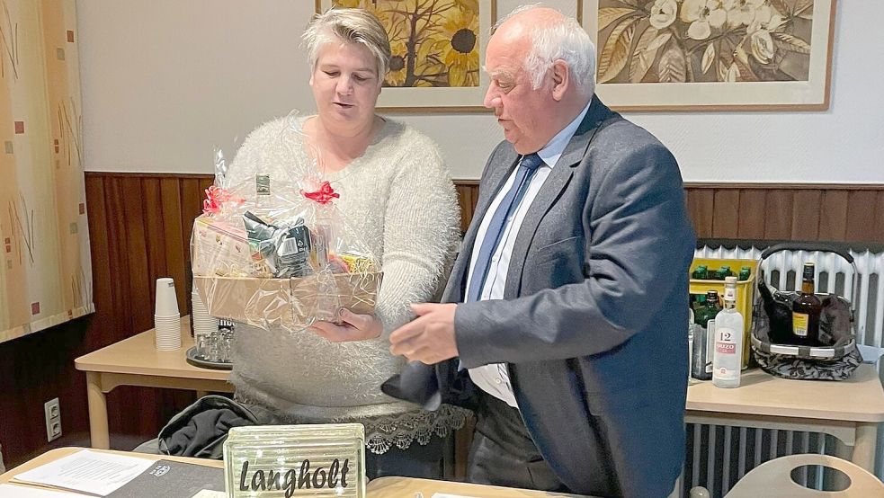 Die neue Ortsbürgermeisterin Andrea Meiners überreichte ihrem Amtsvorgänger Bernhard Robbers einen Präsentkorb und einen Glasbaustein mit der Aufschrift "Langholt sagt Danke". Foto: Laura Kruse/Privat