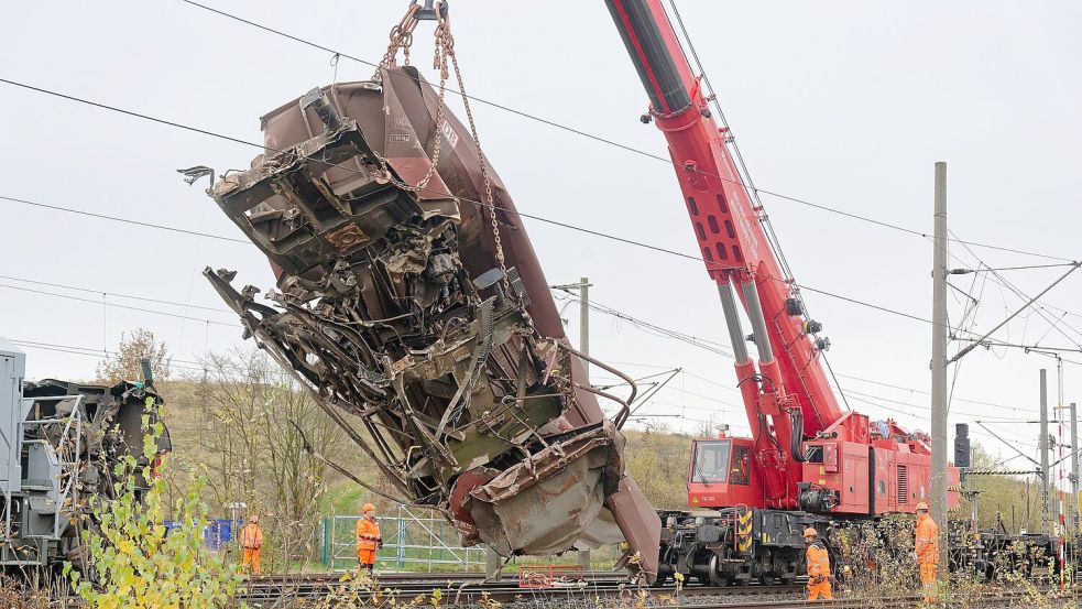 Ein schwerer Kran hob einen ersten Güterwaggon von den Gleisen und stellte ihn neben den Schienen ab. Foto: Henning Kaiser/dpa