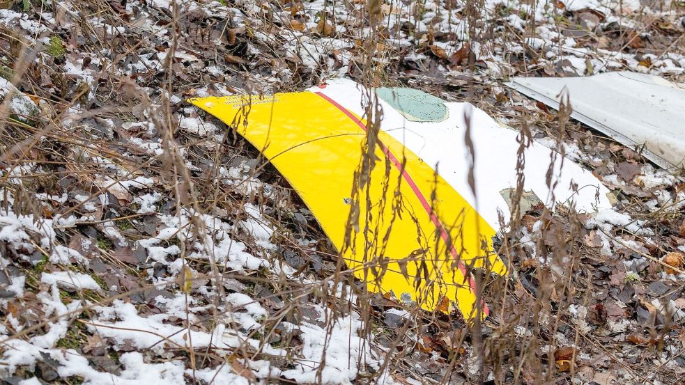 Auf einem Trümmerteil des abgestürzten Flugzeugs sind die DHL-Farben zu sehen. Foto: Mindaugas Kulbis/AP