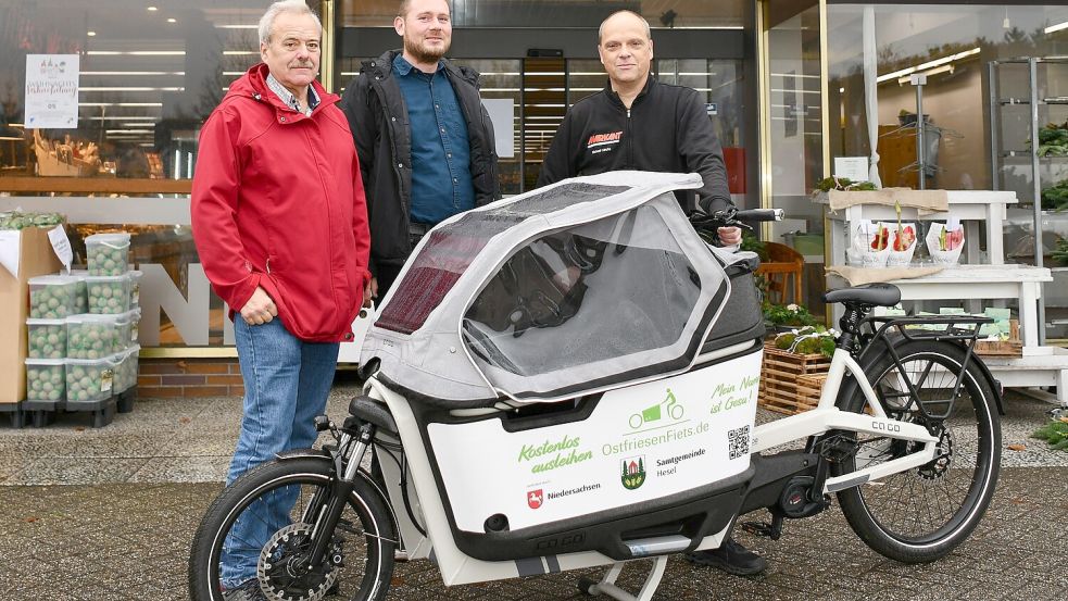 Der Geschäftsführer von Markant in Holtland, Michael Ulrichs (von rechts), hat das neue Lastenrad von Michael Tunder und Uwe Themann von der Samtgemeinde Hesel entgegen genommen. Foto: Stromann