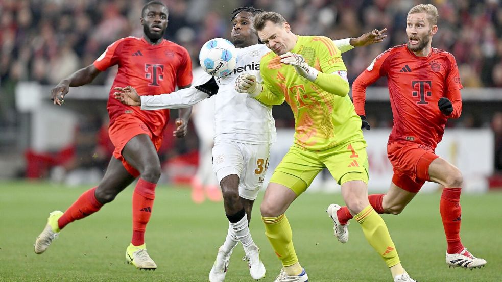 Manuel Neuer kommt zu spät und rammt Leverkusens Jeremie Frimpong um. Foto: Sven Hoppe/dpa