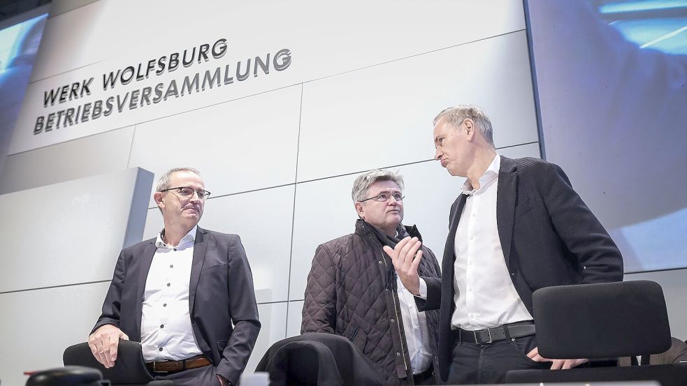 Konzernchef Oliver Blume (r.) berät sich vor seiner Rede mit VW-Verhandlungsführer Arne Meiswinke (Mitte). Foto: Ronny Hartmann/POOL/dpa