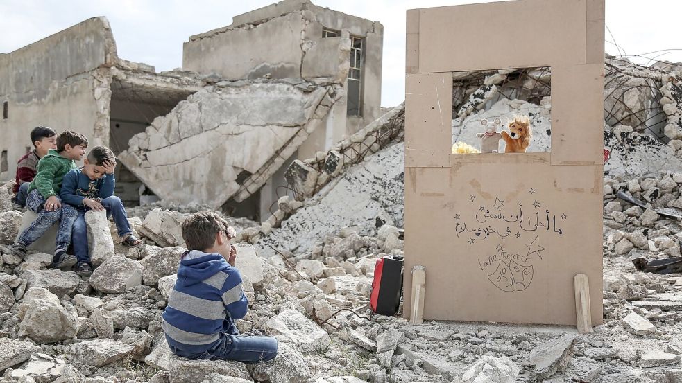 Anas Alkharboutli fotografierte einen Puppenspieler, der in den Trümmern ein Marionettentheater aufführt. Foto: Anas Alkharboutli/dpa