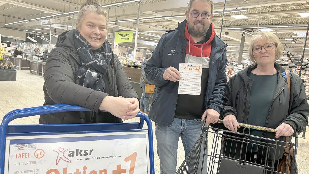 Silke Voskuhl-Hannebohm (von links), Uwe Schulz und Anne Rother von der Tafel werben für die +1-Aktion im Rhauderfehner E-Center. Foto: Janßen