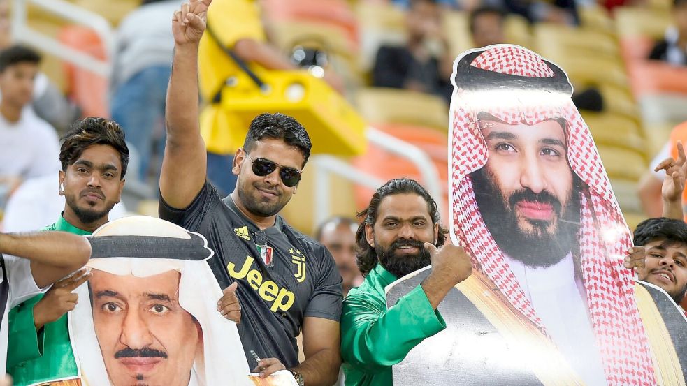 Saudische Fußballfans finden die Sport-Strategie des Königreichs um Kronprinz Mohammed bin Salman (auf dem rechten Plakat) gut. Foto: ---/AP/dpa