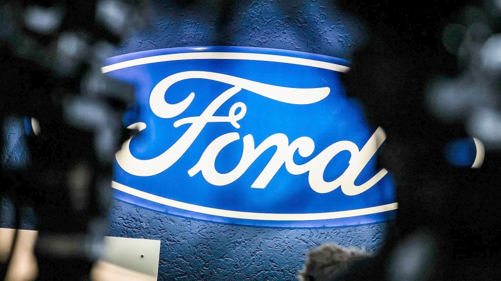 Ein beleuchtetes Firmenschild des Autobauers Ford leuchtet am Rande einer Betriebsversammlung am Standort Köln. Foto: Christoph Reichwein/dpa