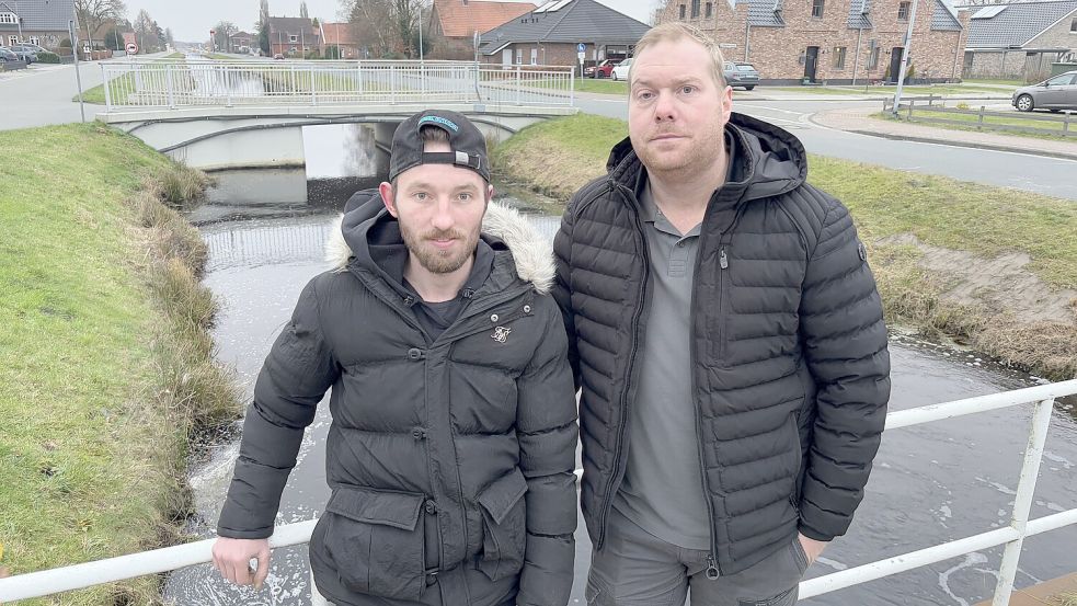 André Tammen (links) und Tim Hinrichs stehen an der Stelle, an der sie am Mittwochmorgen eine 34-jährige Autofahrerin aus dem eiskalten Wasser gerettet haben. Fotos: Zein