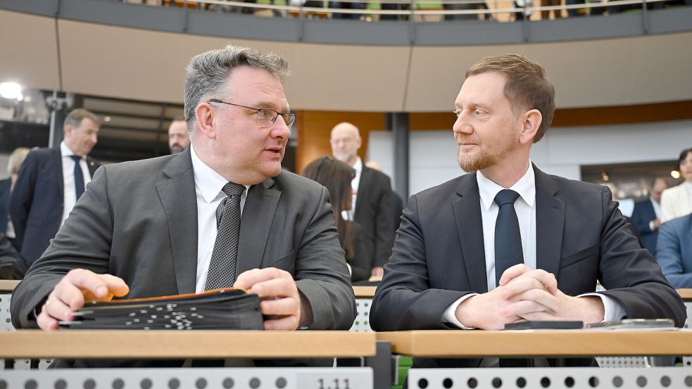 Christian Hartmann (CDU, l), Fraktionsvorsitzender im Sächsischen Landtag, und Michael Kretschmer (CDU), Ministerpräsident von Sachsen, sitzen vor der Wahl eines neuen Ministerpräsidenten von Sachsen im Plenarsaal im Sächsischen Landtag. Foto: dpa/Robert Michael