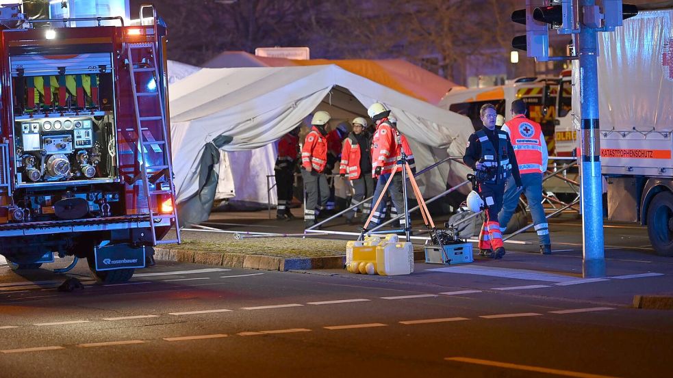 Einsatzkräfte von Rettungsdiensten sind im Einsatz bei einem Zelt für Verletze beim Weihnachtsmarkt in Magdeburg. Foto: Heiko Rebsch/dpa