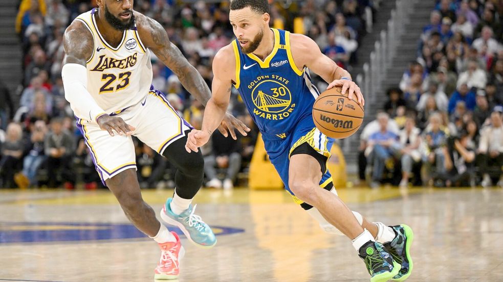 LeBron James (l) und die Los Angeles Lakers setzten sich bei den Golden State Warriors um Stephen Curry durch. Foto: Eakin Howard/AP/dpa