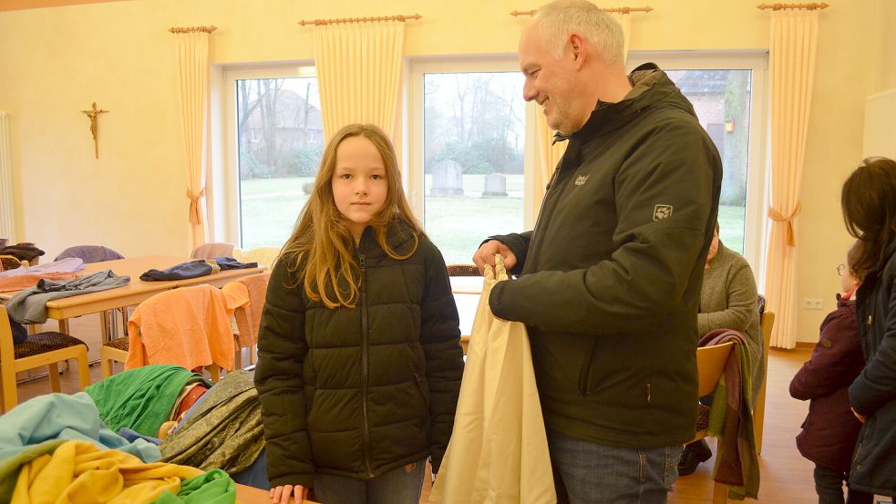 Die elfjährige Louisa Tepe war mit ihrem Vater Dennis Tepe ins Strücklinger Pfarrheim gekommen, um sich ein Kostüm für das Sternsingen auszusuchen. Foto: Fertig