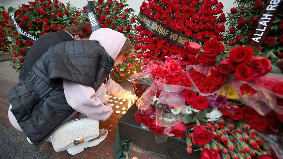 Trauer um die Toten nach dem Absturz in Kasachstan. Foto: Uncredited/AP/dpa