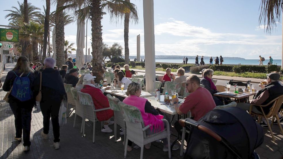 Gut besucht ist bei sonnigem Wetter eine Bar am Strand von Arenal auf Mallorca. Foto: Clara Margais/dpa