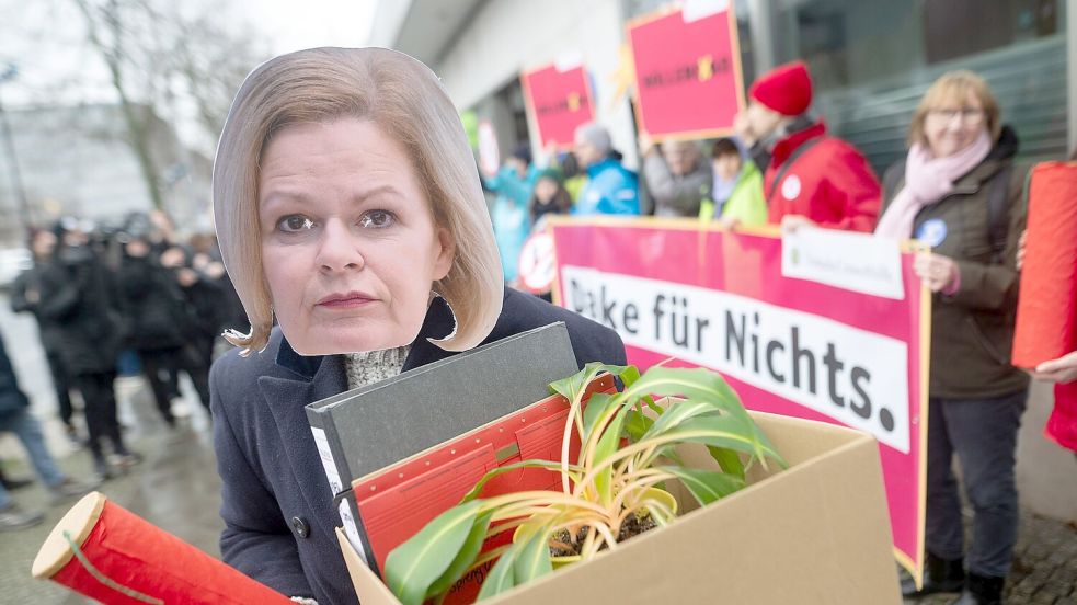 Eine Aktivistin demonstriert mit einer Maske von Bundesinnenministerin Nancy Faeser. Foto: Sebastian Christoph Gollnow/dpa