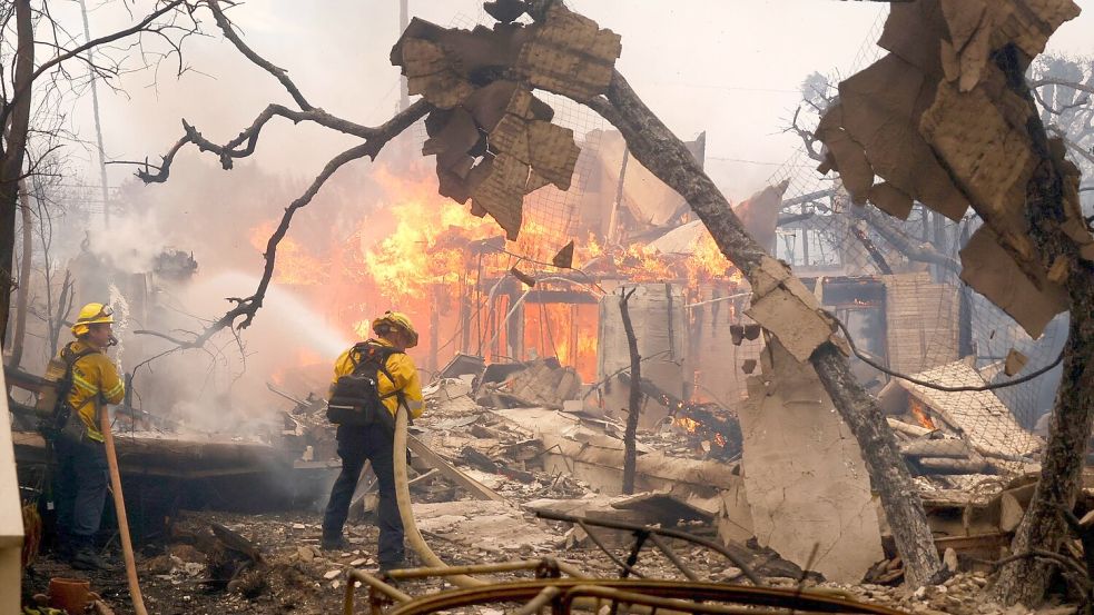 Feuerwehrleute bekämpfen das Palisades-Feuer in Los Angeles. Foto: Etienne Laurent/FR172066 AP/AP/dpa