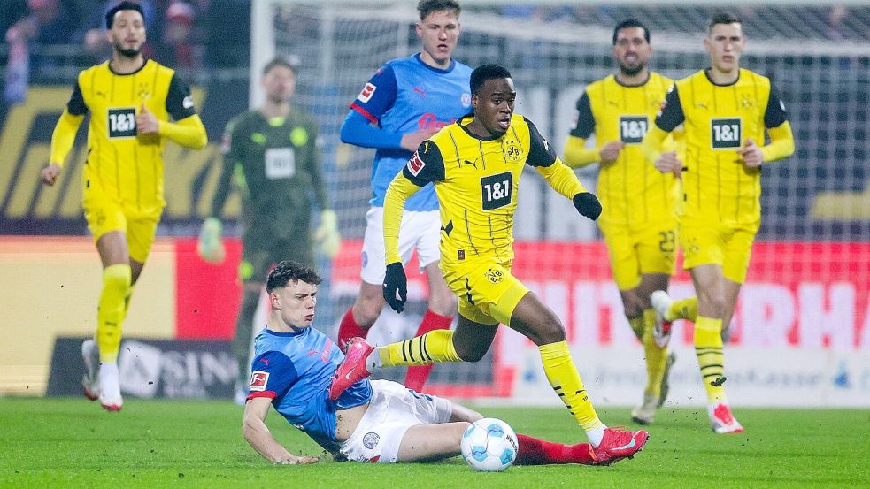 Nicolai Remberg (Holstein Kiel, am Boden) attackiert den Dortmunder Jamie Gittens. Foto: IMAGO/RHR-Foto