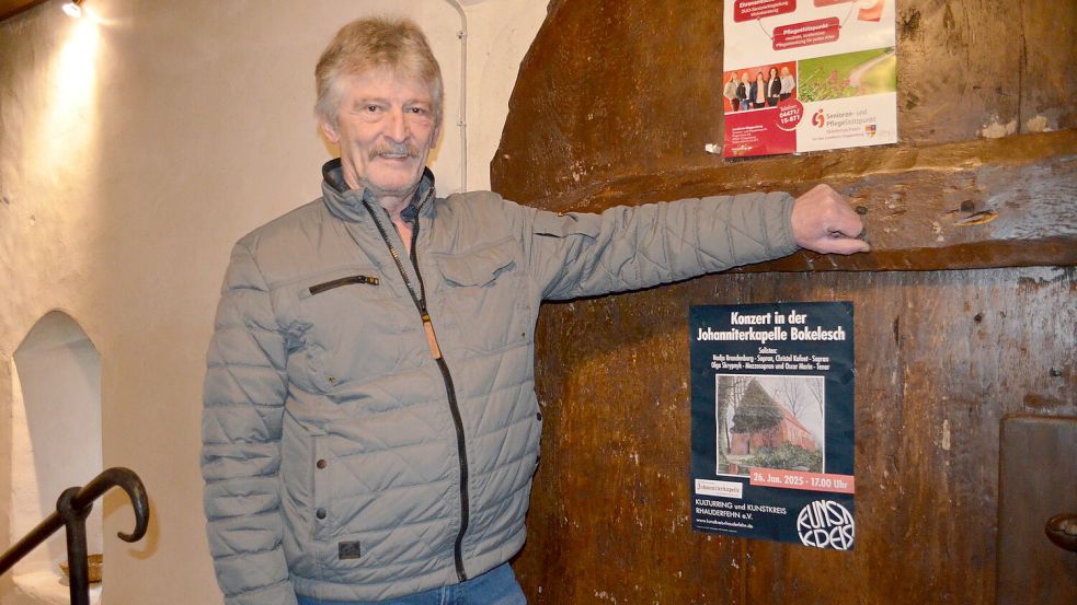 Helmut Sieverding vom Vorstand des Fördervereins der Johanniterkapelle Bokelesch am Eingang der Kapelle. Dort wird mit einem Plakat auf das Konzert hingewiesen, das am 26. Januar in der Kapelle stattfindet. Foto: Fertig