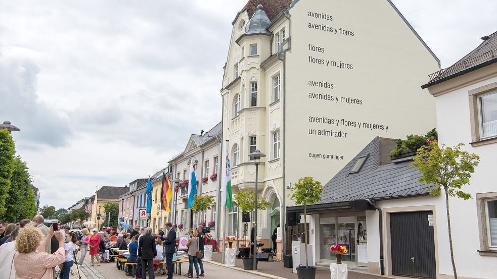 Eugen Gomringers Gedicht „avenidas“ ist an einer Rehauser Hausfassade zu lesen. (Archivbild) Foto: Nicolas Armer/dpa