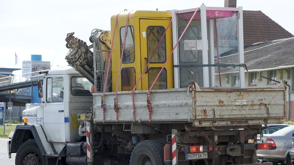 Der Abbau läuft schon seit langem: Hier werden in Sassnitz (Mecklenburg-Vorpommern) im Jahr 2010 zwei Telefonhäuschen zur Entsorgung abtransportiert. (Archivbild) Foto: picture alliance / dpa