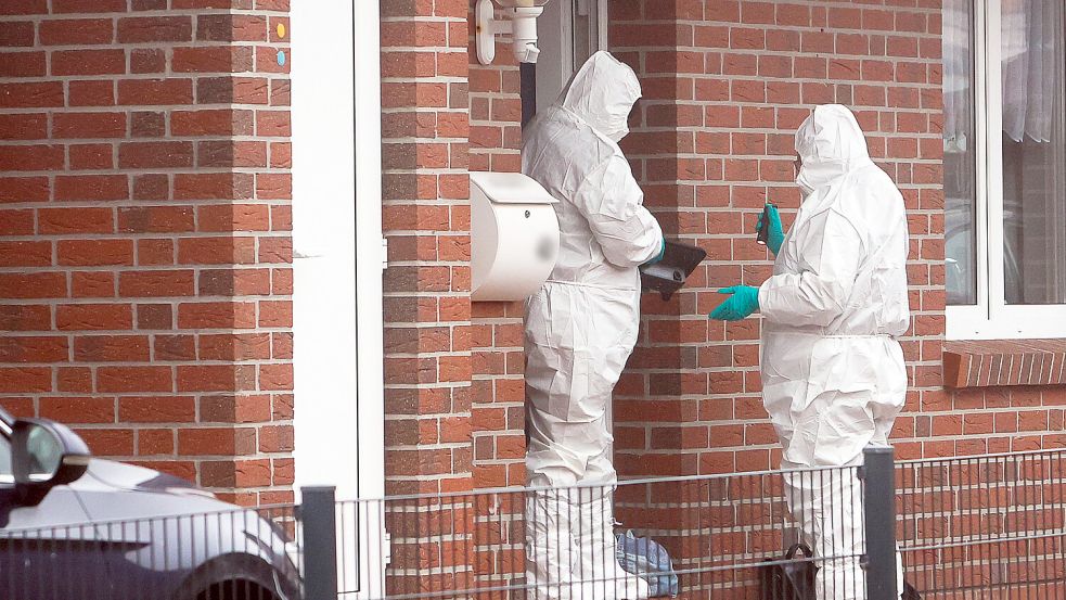 Beamte der Spurensicherung stehen im Stadtteil Larrelt vor einem Einfamilienhaus. Eine Frau ist mutmaßlich von ihrem Partner getötet worden. Foto: J. Doden / Emden