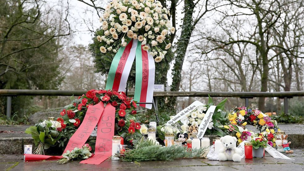 Menschen haben Blumen niedergelegt. Foto: Daniel Löb/dpa