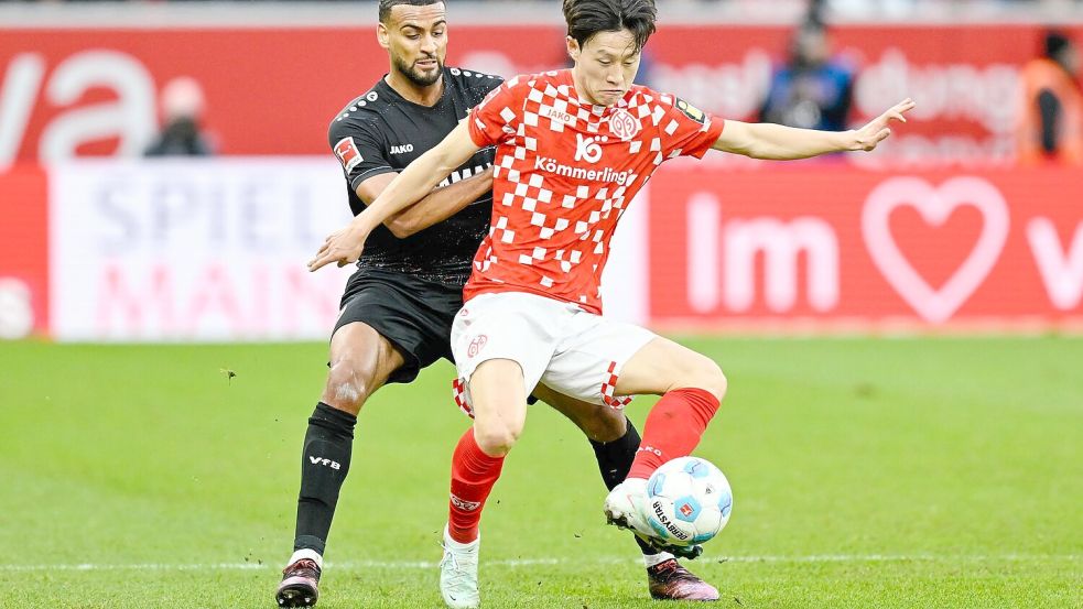 Stuttgarts Josha Vagnoman (l) und Jae-Sung Lee von Mainz 05 lieferten sich ein packendes Duell. Foto: Uwe Anspach/dpa