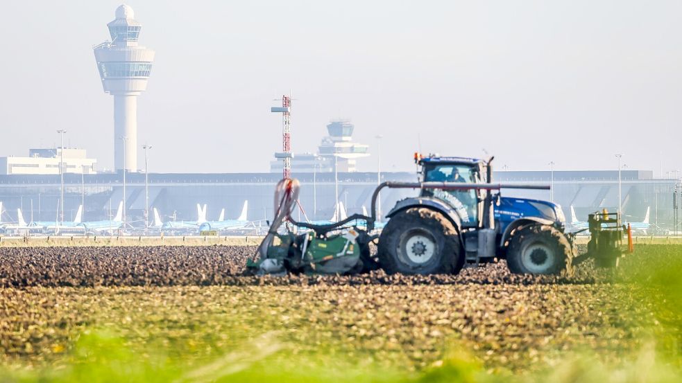 Ein Landwirt arbeitet mit seinem Traktor auf einem Feld nahe des niederländischen Flughafens Schiphol. Foto: Groeneweg/ANP/Imago Images