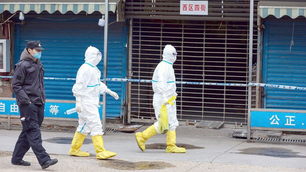 Arbeiter in Schutzkleidung am Huanan Seafood Market in Wuhan. (Archivbild) Foto: -/CHINATOPIX/AP/dpa