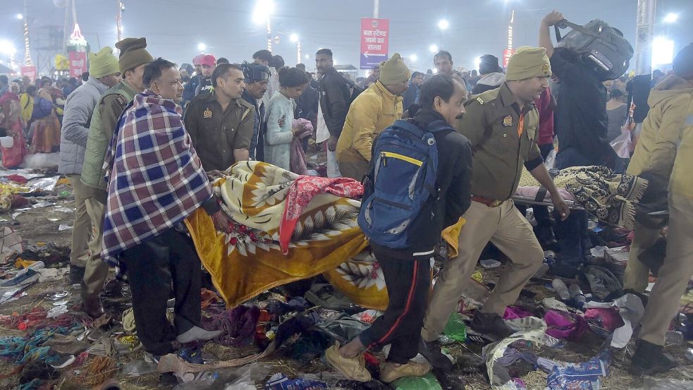 Nach einer Massenpanik tragen Helfer Opfer weg. Foto: Str./XinHua/dpa