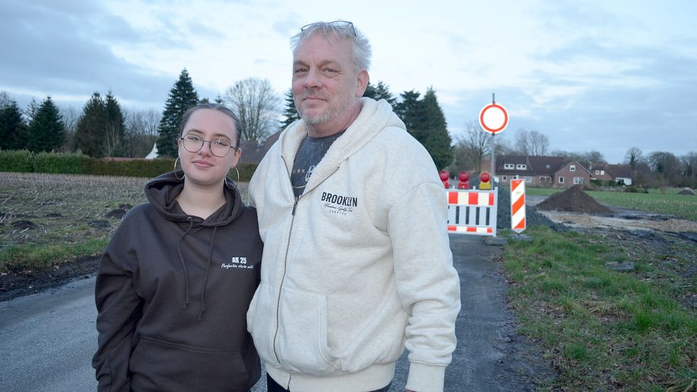 Steffen Dipke und seine 17-jährige Tochter Lea sind Anlieger am Bürgermeister-Tholen-Weg. Dass die Straße ans Kanalnetz angeschlossen wird, finden sie gut. Aber von der Dauerbaustelle, die deshalb daraus wurde, sind sie mittlerweile genervt. Foto: Fertig