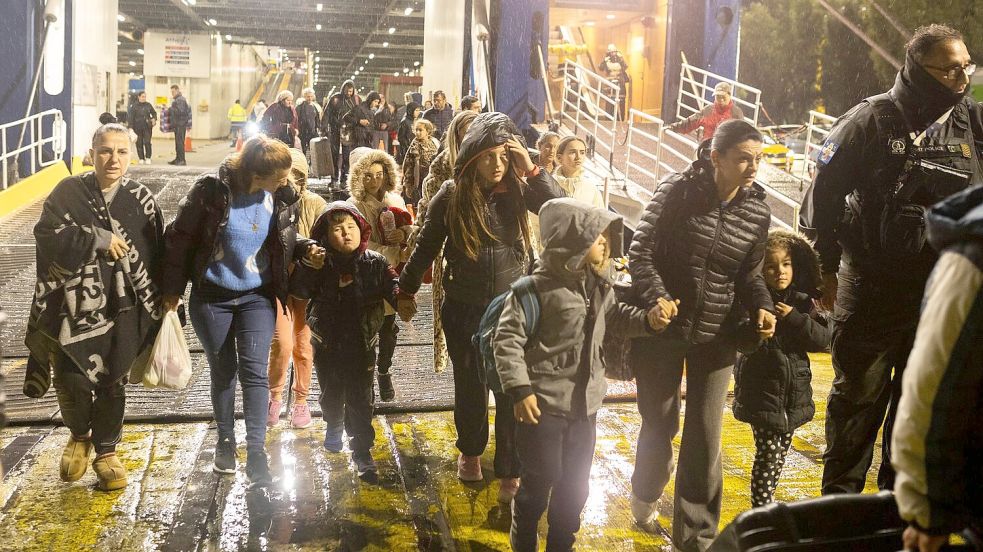 Menschen steigen im Hafen von Piräus von einer Fähre, mit der sie die Insel Santorini verlassen haben. Foto: Socrates Baltagiannis/dpa