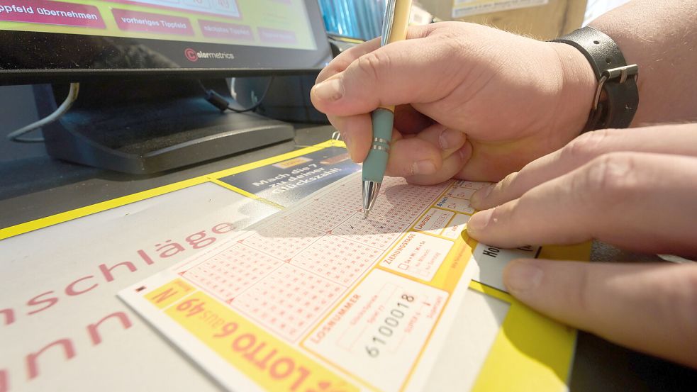 Ein Lottospieler füllt in einer Lotto-Annahmestelle einen Spielschein aus. Foto: DPA