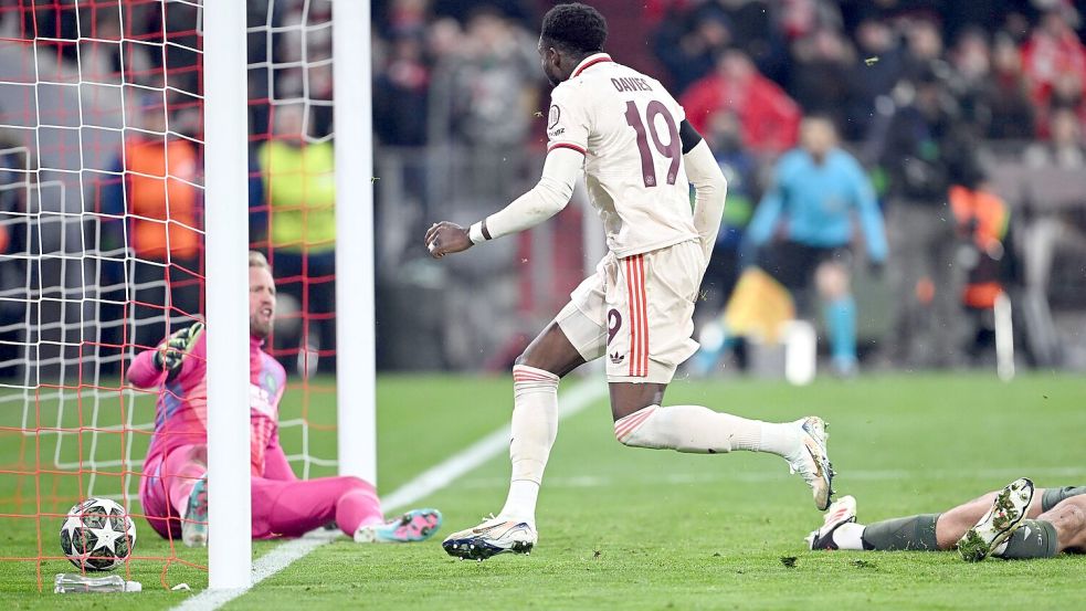 Alphonso Davies stochert den Ball ins Tor, am Boden Celtic-Torwart Kasper Schmeichel (l). Foto: Sven Hoppe/dpa