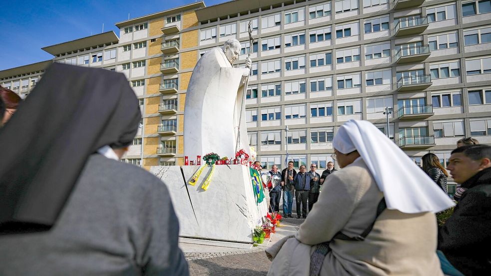 Gläubige versammeln sich vor der Gemelli-Klinik in Rom, um für den Papst zu beten. Foto: Andrew Medichini/AP/dpa