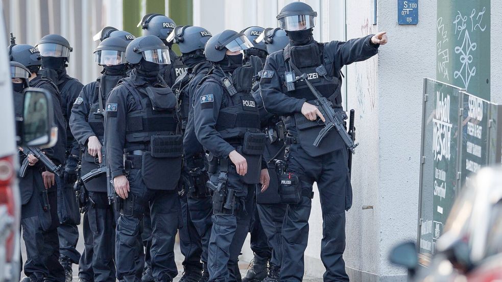 Schwerbewaffnete Einsatzkräfte der Polizei sichern eine Straße vor dem Landgericht in der Innenstadt. Foto: Friso Gentsch/dpa