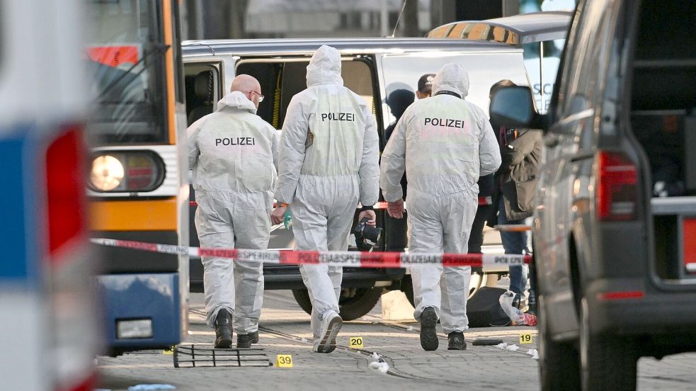 Beamte der Spurensicherung untersuchen den Tatort. Foto: Boris Roessler/dpa