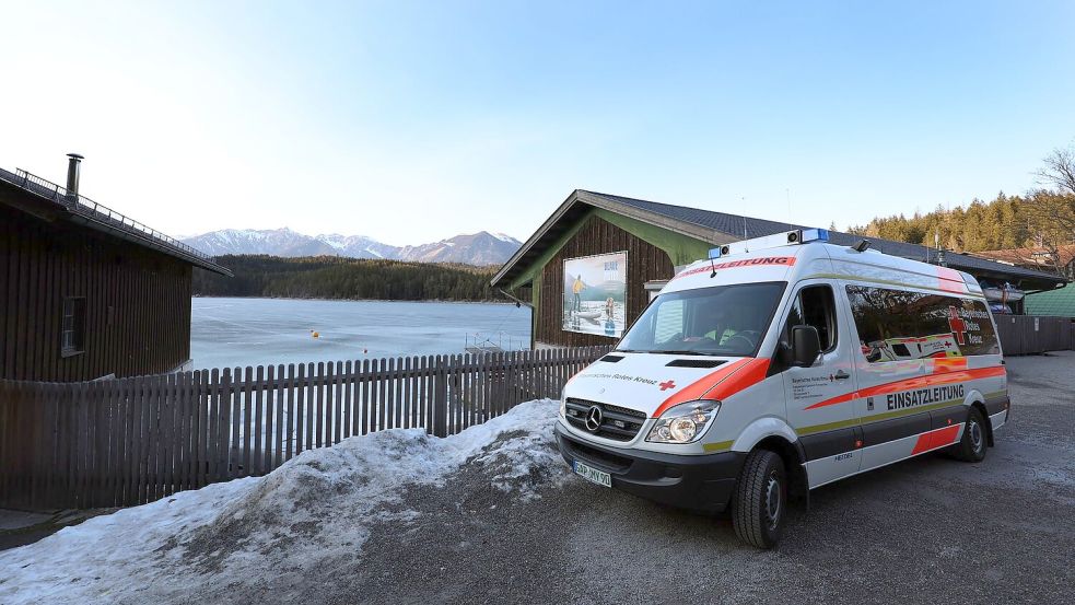 Ein Einsatzfahrzeug des Roten Kreuzes steht am Ufer des Eibsees, nahe der Stelle an der am Nachmittag mehrere Menschen im Eis eingebrochen waren. Foto: Karl-Josef Hildenbrand/dpa