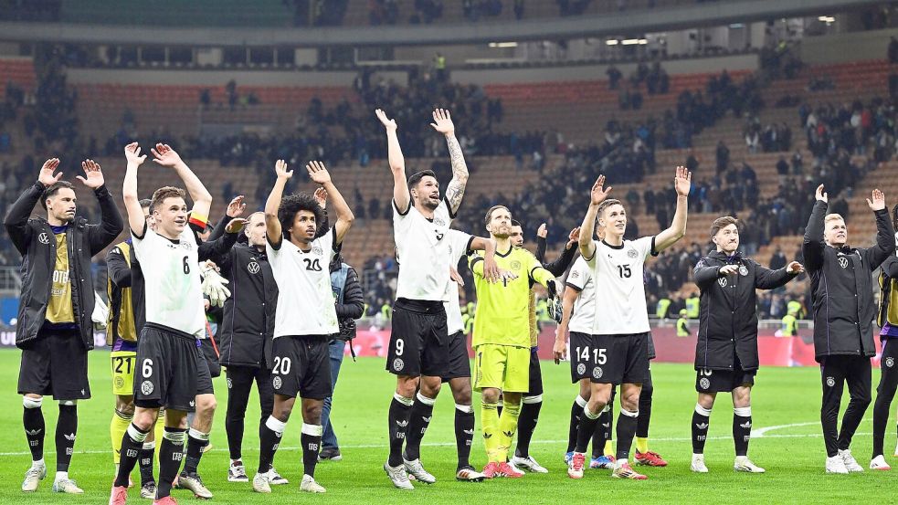 Die deutschen Spieler feiern ihren großen Sieg vor den mitgereisten deutschen Fans. Foto: Federico Gambarini/dpa